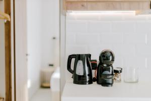 una macchinetta del caffè su una mensola in cucina di Aelia Prime Experience 3 a Città di Kos