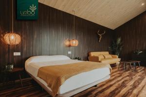 ein Schlafzimmer mit einem großen Bett und einem Stuhl in der Unterkunft Limbo Cabañas de Malpica in Malpica