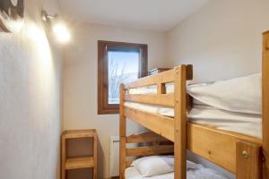 two bunk beds in a small room with a window at Cosy flat with terrace at the foot of the slopes in Megève - Welkeys in Megève