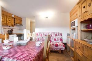a kitchen with a table with a red and white table cloth at Appartement Stampa - Welkeys in Megève