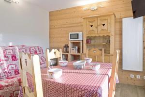 a kitchen with a table with a red and white table cloth at Cosy flat with terrace at the foot of the slopes in Megève - Welkeys in Megève