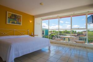 - une chambre avec un lit et une grande fenêtre dans l'établissement Balcon del Alferez, à Xalapa