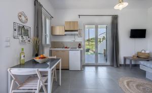 a kitchen and a living room with a table and a counter at Milos Swell Suites II in Pollonia