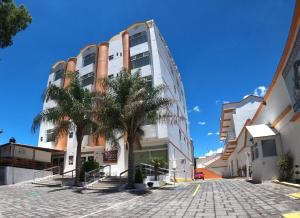 a building with palm trees in front of it at Hotel Señorial Tlaxcala in Tlaxcala de Xicohténcatl