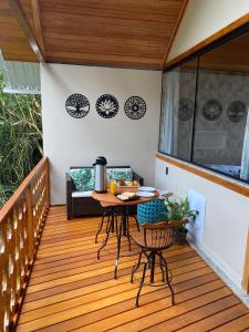 eine Terrasse mit einem Tisch und Stühlen auf einer Terrasse in der Unterkunft Chalés Princesa Isabel in Petrópolis
