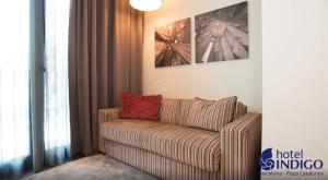 a living room with a couch with a red pillow at Hotel Indigo Barcelona - Plaza Catalunya 4Sup, an IHG Hotel in Barcelona