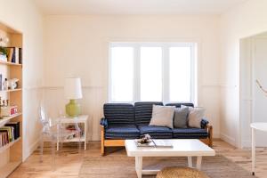 sala de estar con sofá azul y mesa en Blanche de l'Ouest - Îles de la Madeleine en Havre-Aubert