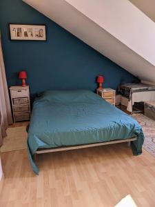 una camera con letto e parete blu di Chambres d'hôtes La Charmante a La Flèche