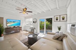 a living room with a couch and a ceiling fan at Amazing 3 Bed House with Gameroom and Fun Backyard in North Miami Beach