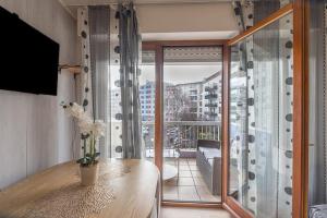 a room with a balcony with a table and a window at Nart & Niar in Annemasse