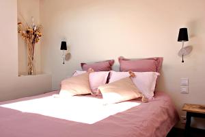 a bedroom with a large bed with pink pillows at Un Jardin Secret in Yzeron