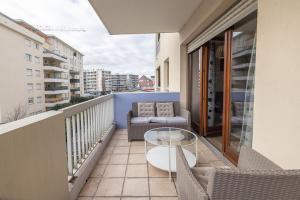 a balcony with a glass table and chairs on a building at Nart&Niar in Annemasse