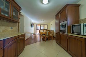 a kitchen with wooden cabinets and a dining room at U Zenona in Stegna