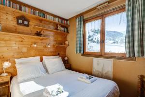 Schlafzimmer mit einem Bett und einem Fenster in der Unterkunft Charming flat with garden nearby the slopes - Welkeys in Megève