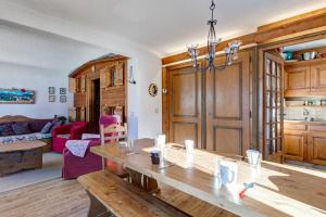 a dining room with a table and a living room at Charming flat with garden nearby the slopes - Welkeys in Megève