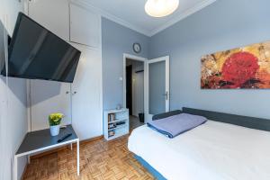 een slaapkamer met 2 bedden en een flatscreen-tv bij LIVANOS Charming Studio Steps from Metro in Athene