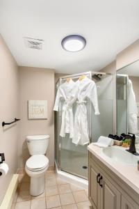a bathroom with a shower and a toilet and a sink at Tremblant Rocher Soleil Ski In Ski Out 2 Bedroom in Mont-Tremblant