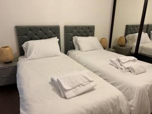 a bedroom with two beds with towels on them at Dartford Lux Stay one bedroom apartment in Dartford