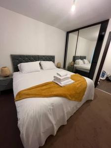 een slaapkamer met een groot bed en een spiegel bij Dartford Lux Stay one bedroom apartment in Dartford