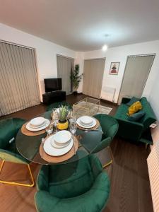 een woonkamer met een tafel en groene stoelen bij Dartford Lux Stay one bedroom apartment in Dartford