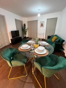 uma sala de estar com uma mesa e cadeiras verdes em Dartford Lux Stay one bedroom apartment em Dartford