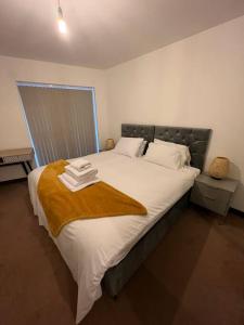 a bedroom with a large bed with towels on it at Dartford Lux Stay one bedroom apartment in Dartford