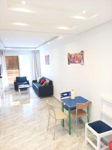 a living room with a table and chairs and a couch at *APPARTEMENT NEUF AVEC TERRASSE À LA MARSA*** in La Marsa