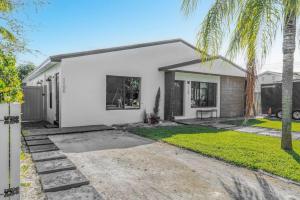 una casa blanca con una palmera delante en Lauderdale Modern 1 Bedroom 1 Bathroom with Private Backyard, en Fort Lauderdale