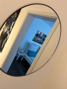 Better Living - Villa - Exklusiv Studio 76qm في مونتابور: مرآة تعكس غرفة مع أريكة زرقاء