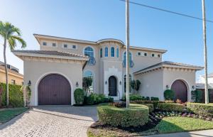 a villa with a garage and palm trees at Southern Exposure I Waterfront 5 Bed House I Wide Water Views of Landmark Bay in Marco Island