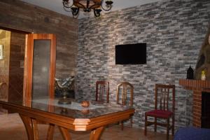 a dining room with a table and chairs and a tv at El Manantial in Jerez de los Caballeros