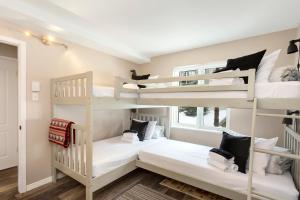 two bunk beds in a room with white walls at Tremblant Rocher Soleil Ski In Ski Out 2 Bedroom in Mont-Tremblant