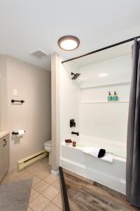 a bathroom with a tub and a toilet in a room at Tremblant Rocher Soleil Ski In Ski Out 2 Bedroom in Mont-Tremblant