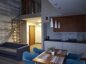 cocina y sala de estar con mesa y sillas azules en HoliApart Apartamenty Krynica No1, en Krynica Morska