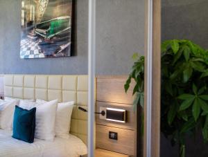 a bedroom with a bed with white pillows and a painting at Casa Hrisicos in Constanţa