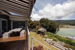 a balcony of a house with a view of the water at Luxury in Kaiteriteri in Kaiteriteri