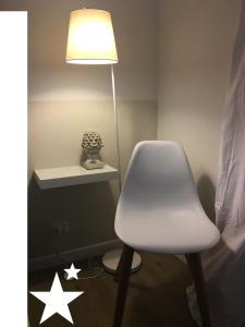 une chaise blanche dans une chambre avec une lampe dans l'établissement Uno splendido punto a Verona!!, à Vérone