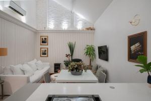 Sala de estar blanca con sofá y mesa en Casa Clássica no Mont Serrat, en Porto Alegre