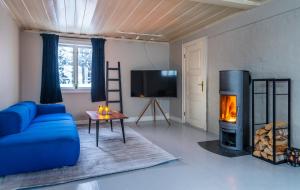 a living room with a blue couch and a fireplace at Arctic Homes - Historical Tromsø House in Tromsø