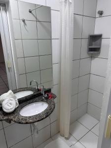 La salle de bains est pourvue d'un lavabo et d'un miroir. dans l'établissement Hotel Pousada Villa Marina, à Fortaleza