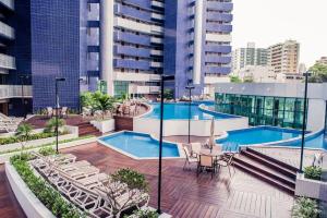 una piscina con mesa y sillas y algunos edificios en Beautiful Beachclass, en Fortaleza