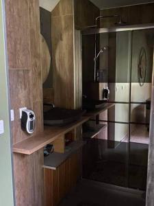 a bathroom with wooden cabinets and a glass shower at Le clos marin (gîte de charme) in Blendecques