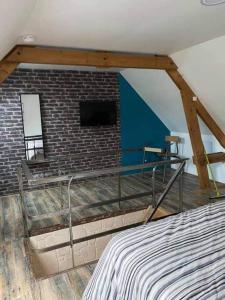 a bedroom with a brick wall and a bed in a room at Le clos marin (gîte de charme) in Blendecques