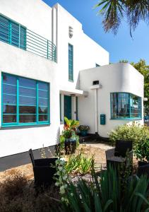 伯青頓的住宿－Twentieth Century B&B，白色的房子,拥有蓝色的窗户和植物