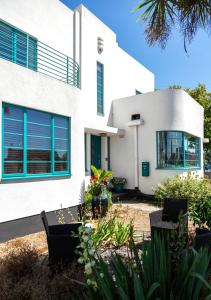 a white house with blue windows and plants at Twentieth Century B&B in Birchington