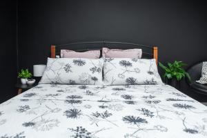 - un lit avec une couette et des oreillers en noir et blanc dans l'établissement Apartmani Majetić, à Valpovo