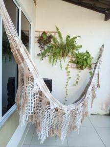 a net hanging on a porch with plants at Casa Aeroporto Maceió in Maceió