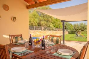 un tavolo in legno con piatti e bottiglie di vino sopra di Precioso chalet Son Calderitx ad Ariany