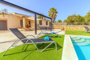 un patio con 2 sedie a sdraio e una piscina di Precioso chalet Son Calderitx ad Ariany