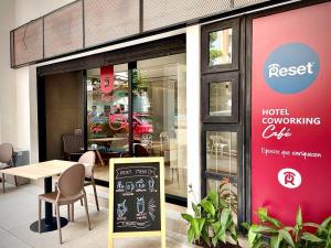 卡利的住宿－Reset (Hotel-Cafe-Coworking)，一间摆有桌子和标志的餐厅